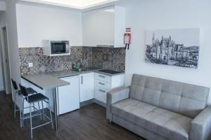 a living room with a couch and a kitchen at Mosteiro View in Batalha