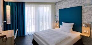 a bedroom with a large bed and a blue wall at Grimm's Potsdamer Platz in Berlin