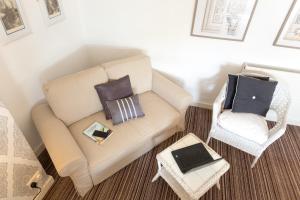a living room with a couch and a chair with a laptop at The Ascott in Manchester