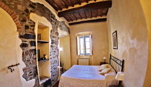 a bedroom with a large bed in a stone wall at Hotel Italia Cortona in Cortona