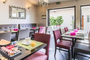 - une salle à manger avec des tables, des chaises et un miroir dans l'établissement Le Figuier, à Ivry-sur-Seine