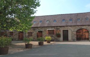 un antiguo granero de piedra con puertas y plantas de madera en Bryn Melyn Farm Cottages, en Bala