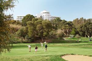 a group of people playing golf on a golf course at TRH Paraíso in Estepona