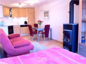a living room with a table and a stove at Appartement Lydie in Le Landeron
