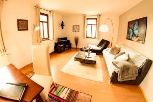 a living room with a couch and a table at Ferienwohnung am Weissen Hirsch in Dresden