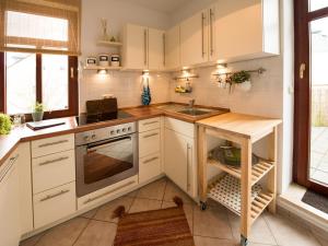 a kitchen with white cabinets and a sink at Ferienwohnung am Weissen Hirsch in Dresden