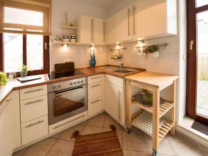 uma cozinha com armários brancos e um lavatório em Ferienwohnung am Weissen Hirsch em Dresden