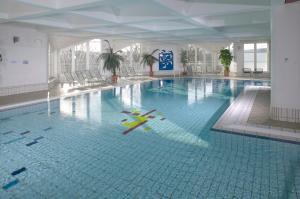 a large swimming pool with a swimmer in the water at Hapimag Ferienwohnungen Winterberg in Winterberg