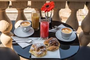 uma mesa preta com duas chávenas de café e pastelaria em Pantheon Caesar Relais em Roma