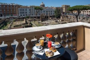 uma mesa com comida numa varanda com vista em Pantheon Caesar Relais em Roma