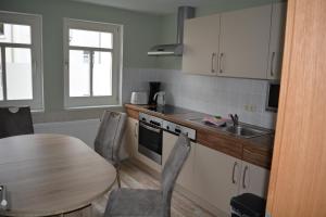 a kitchen with a table and a sink and a table and chairs at Ferienwohnungen "Altes Bachhaus" in Eisenach +20 photos
