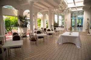 une salle à manger avec des tables et des chaises ainsi qu'un lustre dans l'établissement Bellavista Terme Resort & Spa, à Montegrotto Terme