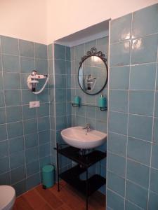 a blue tiled bathroom with a sink and a mirror at Casa di Arianna alle Cinque Terre in Corniglia +16 photos