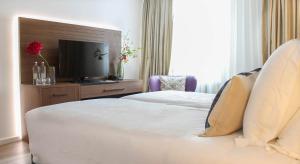 una camera d'albergo con letto e TV di A-Hotel Oosterhout a Oosterhout