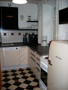 eine Küche mit einem weißen Kühlschrank und einem karierten Boden in der Unterkunft Moselvilla Enkirch in Enkirch