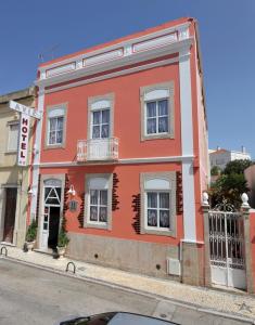 czerwony budynek po stronie ulicy w obiekcie Hotel Aviz w mieście Figueira da Foz