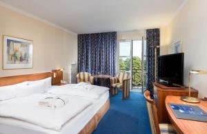 メルゼブルクにあるラディソン ブルー ホテル ハレ - メルセブルクの大型ベッドとテレビが備わるホテルルームです。
