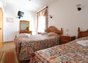 Habitación de hotel con 2 camas y espejo en Hotel Aviz, en Figueira da Foz