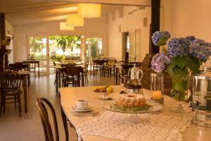 a table with a cake and a vase of flowers on it at Pousada La Vista in Gramado