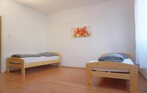 プフォルツハイムにあるFerienwohnung Bauknecht, Pforzheimのベッド2台が備わる客室で、壁には絵画が飾られています。