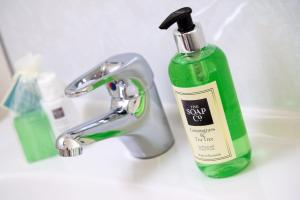 a green bottle of soap sitting next to a sink at Skiddaw Croft Bed & Breakfast in Keswick