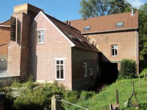 a brick house with a garage in front of it at B&B Molen Ter Walle in Geraardsbergen