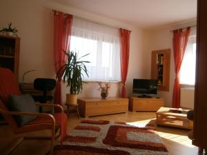 un soggiorno con tende rosse e TV di Ferienwohnung Fischer a Jena