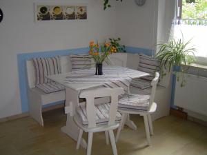 ein weißer Tisch und Stühle mit einer Blumenvase drauf in der Unterkunft Ferienwohnung Fischer in Jena