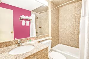 a bathroom with a sink and a toilet and a tub at Ramada by Wyndham Rockaway in Rockaway +25 photos