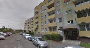 a parking lot with cars parked next to a building at Apartament Zacisze in Częstochowa