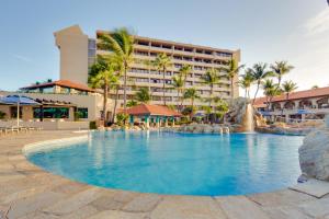 a large swimming pool with a hotel in the background at Barceló Aruba - All Inclusive in Palm-Eagle Beach
