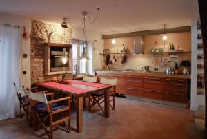 a kitchen with a wooden table and chairs and a kitchen with a counter at Casa Gaino in Toscolano Maderno