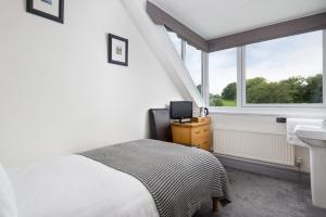 1 dormitorio con cama, lavabo y ventana en Skiddaw Croft Bed & Breakfast en Keswick