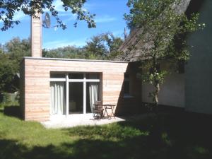 a small building with a chair in a yard at Ferienwohnungen Auszeit und Freizeit in Ahrenshoop