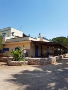 un edificio con una pared de piedra delante de él en La Capasa B&B, en Sannicola