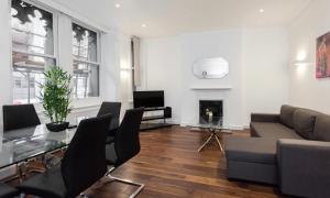 sala de estar con sofá, mesa y chimenea en Fleet Street Apartment 1 en Londres