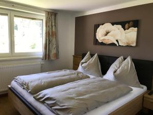 a bed with white sheets and pillows in a bedroom at Sunseitn Apartments in Gosau