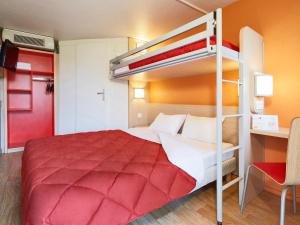 um quarto com um beliche e uma colcha vermelha em Premiere Classe Paris Ouest - Nanterre - La Defense em Nanterre