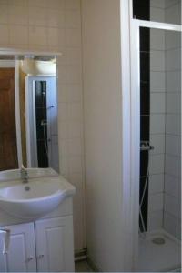 a white bathroom with a sink and a shower at Maison Bord Du Lac in Marcillac-la-Croisille