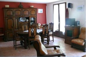 a living room with a dining room table and chairs at Maison Bord Du Lac in Marcillac-la-Croisille