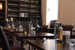 a restaurant with wooden tables with bottles on them at Abdij Hotel Rolduc in Kerkrade