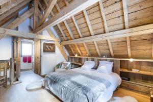 a bedroom with a large bed in a room with wooden ceilings at Chalet Hermine in Megève