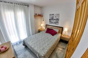 A bed or beds in a room at WonderStays Apartamentos Maribel