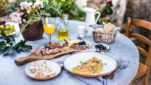 a table with plates of food and drinks on it at Casa Krasna Gourmet Boutique Hotel in Lokev