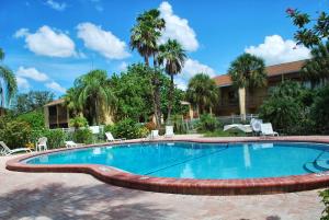 une piscine avec des chaises et un bâtiment dans l'établissement 1/1 bed&bath condos 5 min drive to Siesta, à Sarasota
