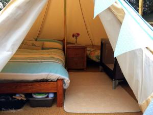 a bedroom with a bed in a tent at Wheal Rodney Holiday Park in Marazion +50 photos