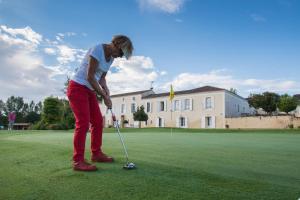 a woman is playing golf on a golf course at Terra Gasconha in Barbaste