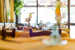 a group of tables with flowers in glass jars at Agriturismo La Sosta in Pescia Romana +37 photos