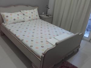 Una cama en un dormitorio con una colcha con flores. en Errica Apartment en Preveza