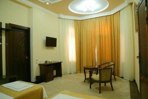 una camera d'albergo con tavolo e sedie e una camera di Muzaffar Hotel Samarkand a Samarkand